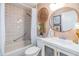 Bathroom with a combination shower and tub, complemented by an updated vanity and peach colored walls at 13205 Cypress Hill Dr, Hudson, FL 34669