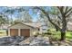 Inviting single-story home with a two-car garage surrounded by mature trees at 13205 Cypress Hill Dr, Hudson, FL 34669