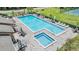 Community pool and spa area with tables and lounge chairs and a manicured lawn at 13205 Cypress Hill Dr, Hudson, FL 34669