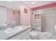 Pink-themed bathroom featuring a single sink vanity and shower-tub combo at 13500 Gulf Blvd # 706, Madeira Beach, FL 33708