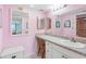 The pink bathroom features a granite countertop with vanity and a shower in the background at 13500 Gulf Blvd # 706, Madeira Beach, FL 33708
