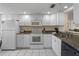 All-white kitchen featuring granite countertops and stainless steel appliances at 13500 Gulf Blvd # 706, Madeira Beach, FL 33708