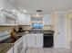 Bright kitchen features granite counters, and white cabinetry, with a view of the ocean at 13500 Gulf Blvd # 706, Madeira Beach, FL 33708