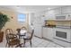 Small dining area features view and connects to a kitchenette with white appliances at 13500 Gulf Blvd # 706, Madeira Beach, FL 33708