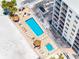 Aerial view of the pool area with loungers, tiki huts, and beach access at 13500 Gulf Blvd # 706, Madeira Beach, FL 33708