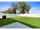 Well-maintained backyard with lush green grass, a white fence, and mature trees creating a private space at 13727 Whiskey Daisy Dr, Dade City, FL 33525