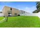Large backyard with well-kept lawn, a white fence, and lush greenery providing a private outdoor area at 13727 Whiskey Daisy Dr, Dade City, FL 33525
