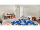 bedroom with shelving unit for toys and books, and a cozy cartoon-themed bedspread at 13727 Whiskey Daisy Dr, Dade City, FL 33525