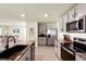 Kitchen features stainless steel appliances, granite countertops, gray cabinets, and an island with counter seating at 13727 Whiskey Daisy Dr, Dade City, FL 33525
