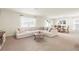 Cozy living room featuring a large sectional sofa, a round coffee table, and a view into the dining area at 13727 Whiskey Daisy Dr, Dade City, FL 33525