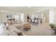 Open-concept living room boasts a kitchen with a breakfast bar and comfortable seating in a bright, airy space at 13727 Whiskey Daisy Dr, Dade City, FL 33525