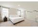 Bright bedroom with a white tufted headboard, two windows, and views into the en suite bathroom at 13727 Whiskey Daisy Dr, Dade City, FL 33525