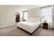 Comfortable bedroom with a plush white bed, two windows, and an adjacent walk-in closet at 13727 Whiskey Daisy Dr, Dade City, FL 33525