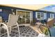 Back patio with sun-shade has comfortable seating next to sliding glass door into home at 13920 Berkowitz Ave, Hudson, FL 34667