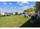 Large lawn in backyard features an air conditioning unit, canal access, and a sun-shaded back patio at 13920 Berkowitz Ave, Hudson, FL 34667