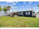 Large lawn in backyard features a sun-shaded back patio and boat canal access at 13920 Berkowitz Ave, Hudson, FL 34667