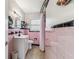 Retro bathroom design, featuring pink tile, white vanity, and black trim at 13920 Berkowitz Ave, Hudson, FL 34667