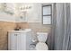 Guest bathroom features a bright vanity with a sink and toilet near the shower with a window at 13920 Berkowitz Ave, Hudson, FL 34667