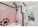 Retro bathroom features pink tiling with black accents in the shower and an adjacent opening at 13920 Berkowitz Ave, Hudson, FL 34667