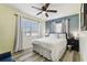 Light filled bedroom with plank floors, a ceiling fan, and two bright windows at 13920 Berkowitz Ave, Hudson, FL 34667
