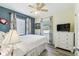 Cozy bedroom with plank floors, white bedding, and bright natural light from two windows at 13920 Berkowitz Ave, Hudson, FL 34667