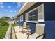 Side view of a blue home featuring shuttered windows and a front porch with comfortable seating at 13920 Berkowitz Ave, Hudson, FL 34667