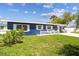 Quaint single-story blue house with white trim, a tidy front lawn, and a welcoming white picket fence at 13920 Berkowitz Ave, Hudson, FL 34667