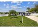 Charming single-story home with a well-manicured lawn, palm trees, and a freshly painted exterior at 13920 Berkowitz Ave, Hudson, FL 34667