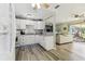 Bright kitchen featuring white cabinets, stainless steel appliances, and an open layout into the living room at 13920 Berkowitz Ave, Hudson, FL 34667