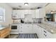 Well-lit kitchen with white cabinets, modern appliances, and stylish backsplash at 13920 Berkowitz Ave, Hudson, FL 34667