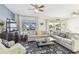 Inviting living room with sectional, blue rug, and lots of natural light coming through windows at 13920 Berkowitz Ave, Hudson, FL 34667
