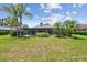Expansive backyard with lush green grass, mature trees, and screened-in patio with swimming pool at 14170 Fennsbury Dr, Tampa, FL 33624