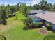 Expansive backyard featuring lush green lawn and landscaping with palm trees and hedges at 14170 Fennsbury Dr, Tampa, FL 33624