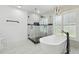 Luxurious bathroom featuring a freestanding tub, glass shower, and modern lighting at 14170 Fennsbury Dr, Tampa, FL 33624