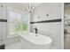 Freestanding tub under a window with shutters and a modern chandelier provides a spa-like retreat at 14170 Fennsbury Dr, Tampa, FL 33624