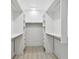 Walk-in closet with custom shelving, drawers and modern track lighting at 14170 Fennsbury Dr, Tampa, FL 33624