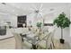 Open-concept dining room with designer light fixture and view of fireplace and kitchen at 14170 Fennsbury Dr, Tampa, FL 33624