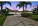 Charming single-story home featuring a lush front yard, mature trees, and a driveway at twilight at 14170 Fennsbury Dr, Tampa, FL 33624