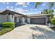 Charming single-story home with a manicured lawn, gray painted accents, and a two-car garage at 14170 Fennsbury Dr, Tampa, FL 33624