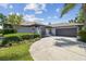 A well landscaped home with a light grey exterior and grey accents and a large driveway at 14170 Fennsbury Dr, Tampa, FL 33624