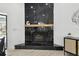 Modern fireplace featuring striking black marble and a wooden mantel at 14170 Fennsbury Dr, Tampa, FL 33624