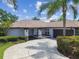 Single story home with a large, well-maintained front yard, mature trees, and circular driveway at 14170 Fennsbury Dr, Tampa, FL 33624