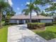 Charming single-story home featuring a lush front yard, mature trees, and a driveway at 14170 Fennsbury Dr, Tampa, FL 33624