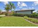 A green front yard with lush, trimmed hedges and edging around the grass at 14170 Fennsbury Dr, Tampa, FL 33624