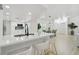 Open kitchen with white cabinetry, a large quartz island, and a view of the dining area at 14170 Fennsbury Dr, Tampa, FL 33624
