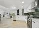 Modern kitchen with stainless steel appliances, white cabinets, and an open view into the living room at 14170 Fennsbury Dr, Tampa, FL 33624