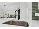 Modern kitchen features a stainless steel sink, quartz countertops, and green tile backsplash at 14170 Fennsbury Dr, Tampa, FL 33624