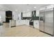 Bright kitchen featuring stainless steel appliances, white cabinets, and light hardwood flooring at 14170 Fennsbury Dr, Tampa, FL 33624