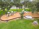 Aerial view of a well-maintained playground with slides, and play structures nestled among mature trees and lush green grass at 14170 Fennsbury Dr, Tampa, FL 33624