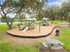 Community playground with slides and various play structures, set in a grassy area with mature trees providing shade at 14170 Fennsbury Dr, Tampa, FL 33624